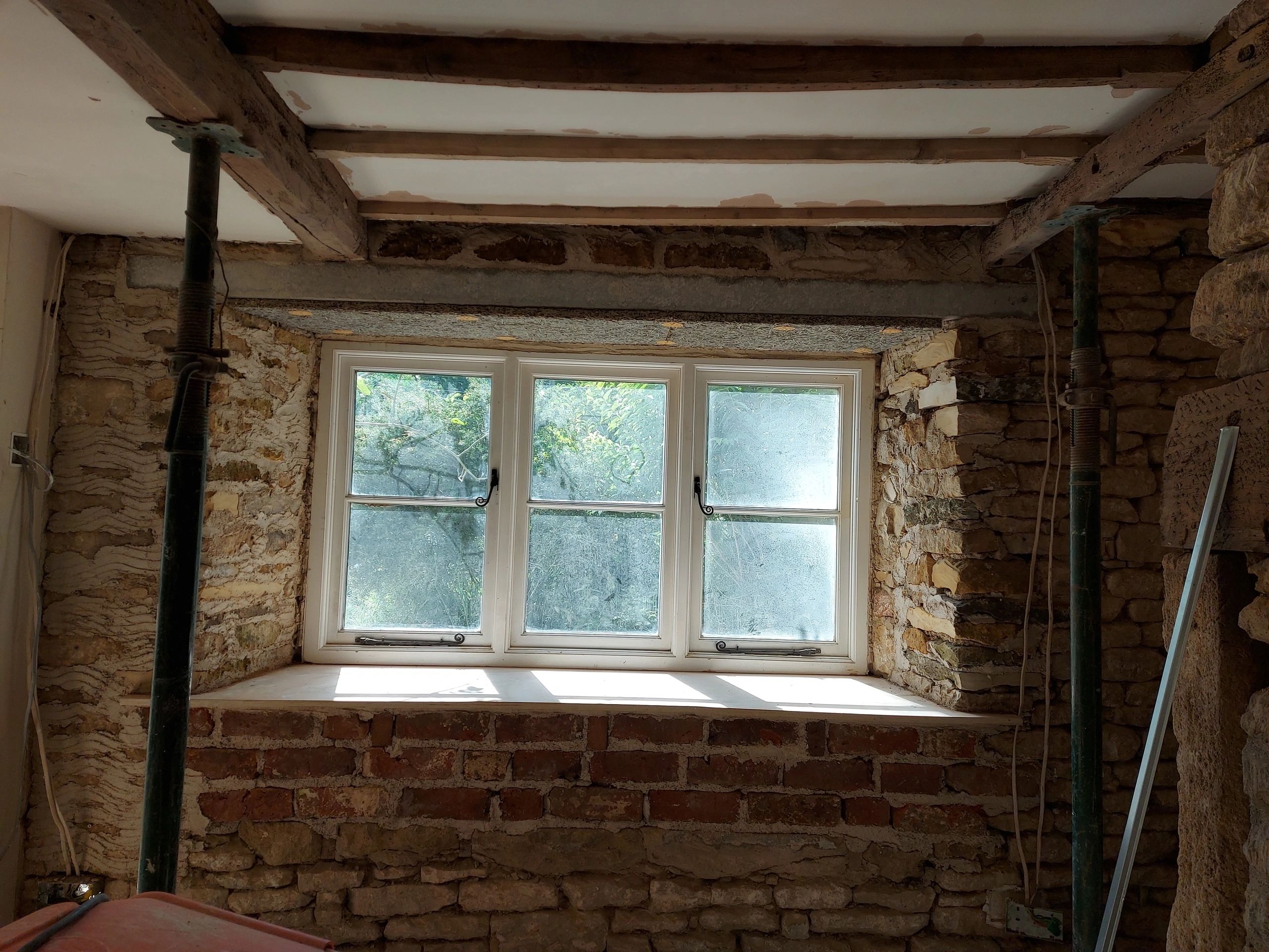 Rustic lime plastered interior with stone wall